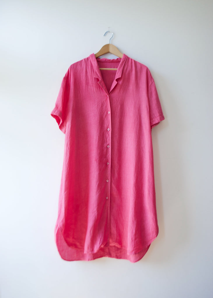 Pink shirtdress on a hanger with a light background