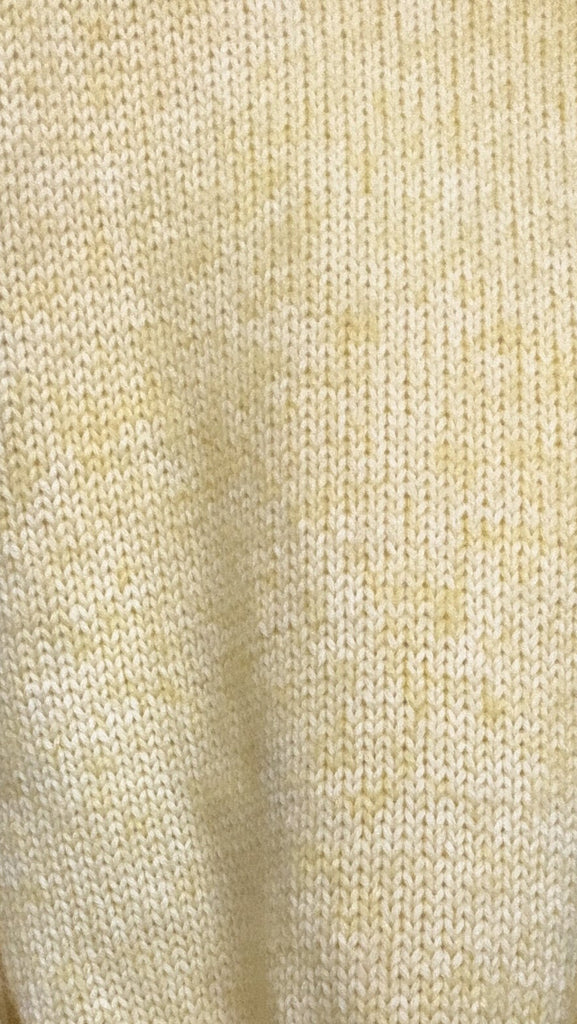 Close-up of light yellow knit sweater texture