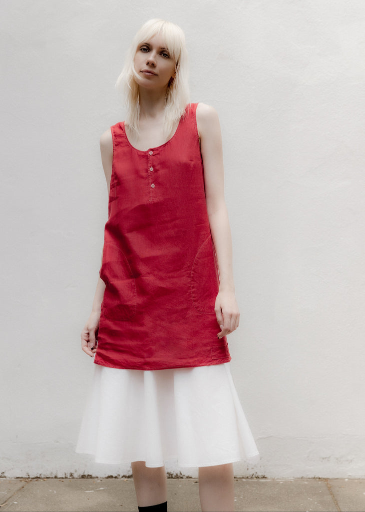 Person wearing a red sleeveless dress with a plain background