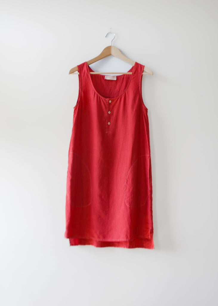 Red sleeveless dress on a hanger against a white background